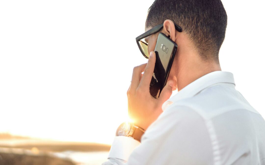shallow focus photography of a man in white collared dress shirt talking to the phone using black android smartphone